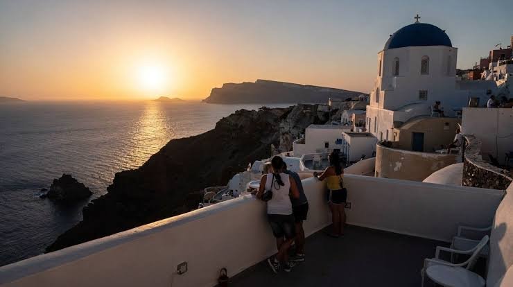 Whitewashed buildings and blue domes over the caldera in Santorini at sunset